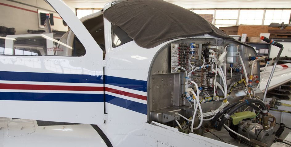 Small airplane with engine exposed for maintenance.